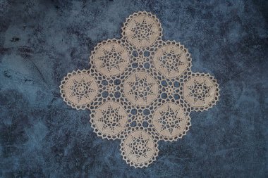 Handcrafted lace tablecloth, coffee table cover. Warm white or beige vintage knit lace. Crochet lace handcrafted lace texture. abstract for background. top view.