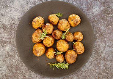 Biberiye ve tuz bir kızartma tavası, kırmızı kabuk, iştah açıcı yemek bütün küçük patates kızartması (pişmiş)