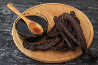 Beyaz arka planda keçiboynuzu (Carob) pekmezi