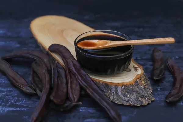 Beyaz arka planda keçiboynuzu (Carob) pekmezi