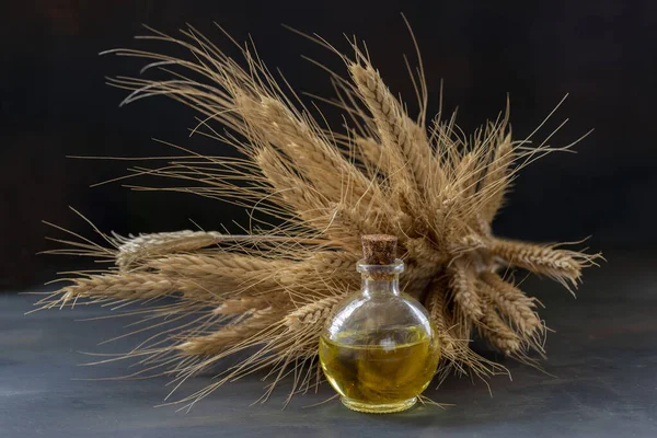 stock image Wheat oil, wheat ears and wheat grains in the bottle.