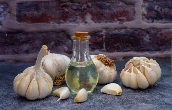 Garlic oil with Garlic Clove and Bulb isolated on wooden table.