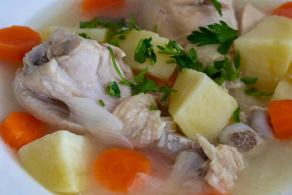 stock image Boiled chicken thigh with potatoes and carrots. Chicken soup .