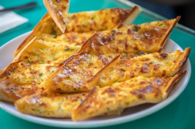 Odun ateşinde pişmiş otlu ve peynirli pide.