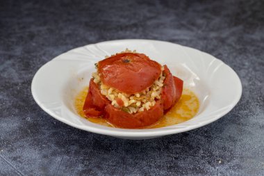 Beyaz tabakta bir domates dolması. Vejetaryen yemeği.