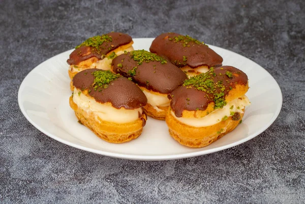 Eclairs with chocolate topping on serving plate