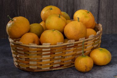 Taze portakallar ve mandalinalar sepete.