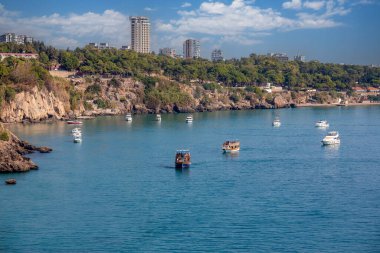 ANTALYA, Türkiye - 24 Ekim 2023: Antalya 'nın güzel körfezlerinden biri olan Lara sahilinde demirli küçük tekneler.