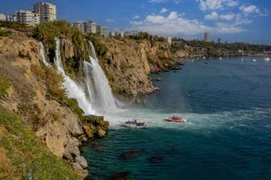 Aşağı Duden şelalesinin denize döküldüğü an Akdeniz 'in sarp kıyılarına ve Antalya şehrinin kentsel gelişimine karşı..