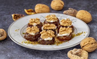 Geleneksel kurutulmuş incir tatlısıyla ceviz ve krema, şurupla pişirilir (Türkçe adı: kremalı incir tatlısı)
