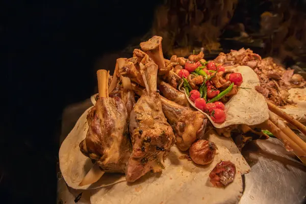 Turkish traditional dish, lamb shank dish cooked in the oven until soft. Lamb shank served with vegetables in lavash bread.