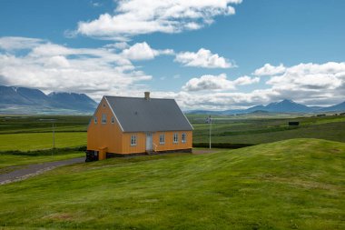 İzlanda kırsalındaki yeşilliklerin arasında yalnız bir ev..