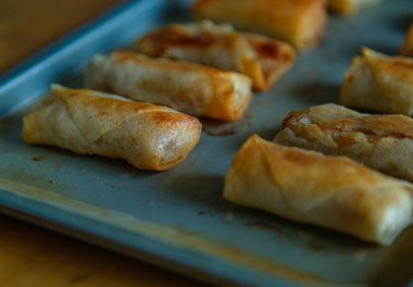 Taze pişmiş börekler bir yemek tepsisi üzerinde düzenlenir. Pişmiş yağda kızartılmış börek. Dış görünüşü altın gibi ve çıtır çıtır, dış dokusu çıtır çıtır ve içi yumuşacık. Çok lezzetli bir aile yemeği..