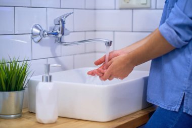 İnsan banyo lavabosunda sıvı antibakteriyel sabunla ellerini yıkıyor. Günlük koruma ve virüslerden, mikroplardan ve bakterilerden korunma