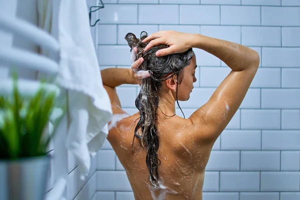 발가벗은 여자가 샤워기를 하면서 샴푸로 머리를 — 스톡 사진