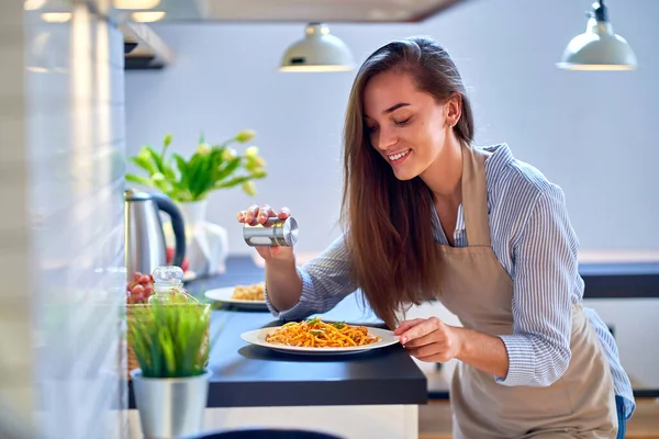 幸せな幸せな喜びを笑顔かわいい料理女性主婦塩と夕食のための食品を準備 — ストック写真