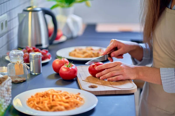 調理女性シェフカットA新鮮な有機熟したトマト上まな板上準備夕食のための現代的なキッチン — ストック写真