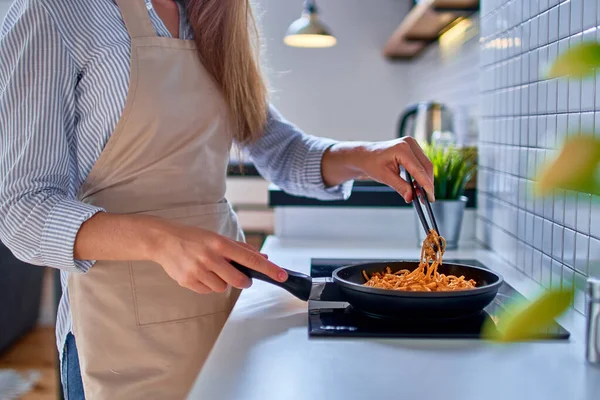 현대식 로프트식 주방에서 식사를 오븐에 올려놓은 프라이팬에서 음식을 준비하고 앞치마를 — 스톡 사진