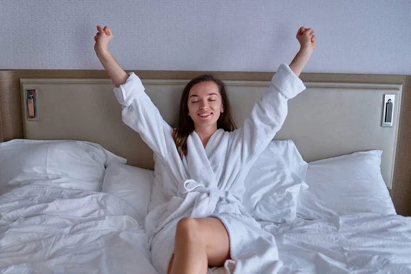 목욕용 즐거운 미소짓는 게으른 여인은 침실에서 휴식을 취하는 아침에 — 스톡 사진