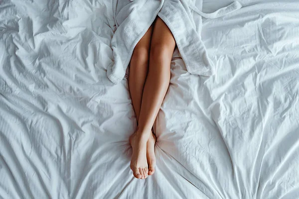 Ледача Жінка Халаті Тонкими Гладкими Довгими Ногами Лежить Білому Ліжку — стокове фото