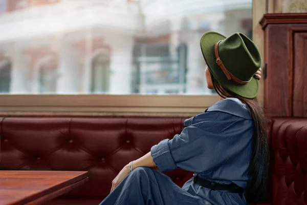 カフェショップで休憩中に一人で座って窓の外を見て感じた帽子を身に着けているスタイリッシュでエレガントな1つのPential思慮深いヒップスター女性旅行者 — ストック写真