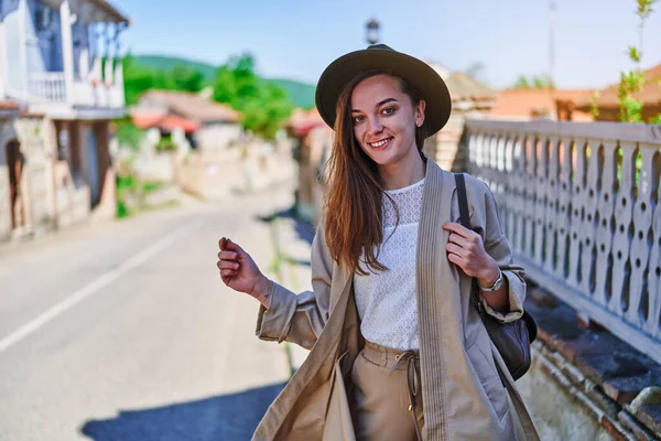 可愛い幸せな幸せな魅力的な笑顔の肖像明るい晴れた日に帽子とバックパックを身に着けている若い女の子の旅行者 — ストック写真