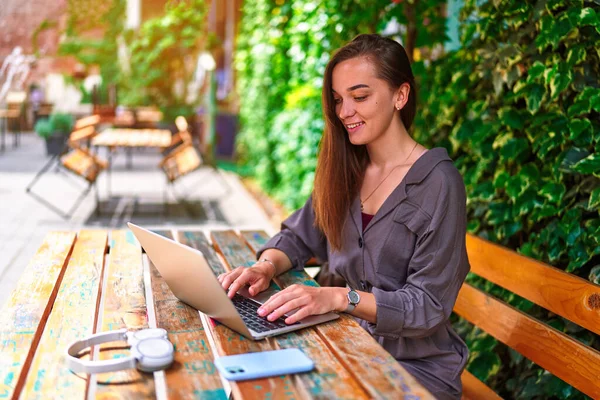 미소짓기 아름다운 역사의 프리랜서 소녀가 카페에서 온라인 작업을 노트북을 사용하는 — 스톡 사진