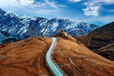 Stepantsminda, Gergeti, Georgia 'daki dağdaki Kutsal Üçlü Tsminda Sameba Kilisesi' ne giden yol.