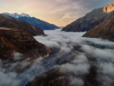 Nehrin üzerinde akşam sisi olan görkemli manzaralı dağ sırası.