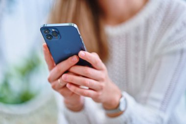 Gürcistan - 07 Ekim 2021 - Çevrimiçi tarama ve sanal sohbet için Pasifik mavisi Iphone 12 Pro Max 'i kullanarak