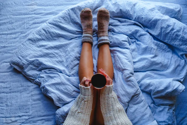Затишна Жінка Теплому Светрі Язані Шкарпетки Сидять Якому Білому Ліжку — стокове фото