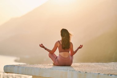 Gün batımında güzel manzaralı meditasyonun tadını çıkaran mutlu bir kadın. Rahatlama stresi ve sağlıklı zihinler 