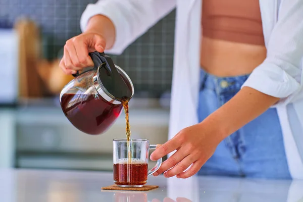 Mutfağında Çaydanlıktan Cam Fincana Siyah Çay Döken Bir Kadın — Stok fotoğraf