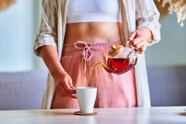 Sıcak Aromatik Siyah Çayı Evdeki Cam Çaydanlıktan Bardağa Dolduran Kadın — Stok fotoğraf
