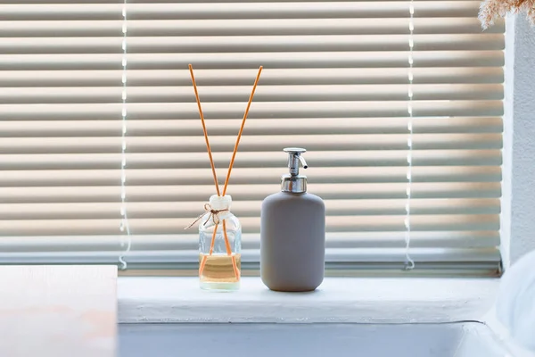 浴室里装有木制香味棒和一瓶液体肥皂的玻璃瓶 — 图库照片