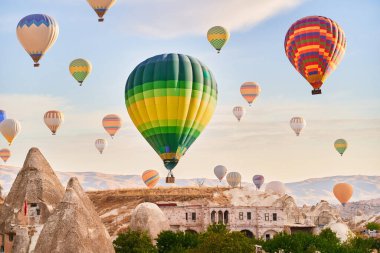 Muhteşem Kapadokya manzarası. Anadolu 'da güneş doğarken gökyüzünde renkli uçan balonlar. Türkiye 'nin Goreme kentinde tatil 