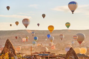 Muhteşem Kapadokya manzarası. Anadolu 'da güneş doğarken gökyüzünde renkli uçan balonlar. Türkiye 'nin Goreme kentinde tatil 