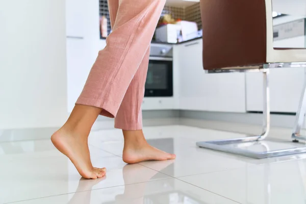 女性赤脚在家里厨房温暖的地板上 — 图库照片