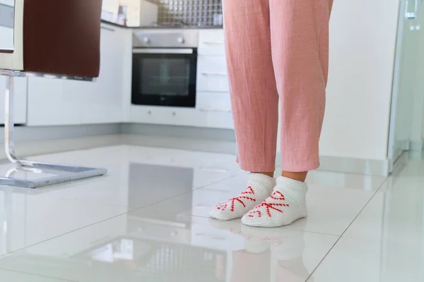 厨房暖烘烘的地板上 女性的腿穿着舒适舒适柔软的针织长袜 — 图库照片