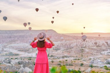 Anadolu, Kapadokya 'da vadide yürüyen özgür, mutlu, ilham verici kız gezginin arkası. Nevsehir, Goreme 'de güzel bir yerde uçan balonlar.