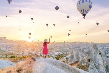 Anadolu, Kapadokya 'da vadide yürüyen ücretsiz ilham verici kız gezgin. Nevsehir, Goreme 'de güzel bir varış noktasında uçan balonlar.