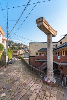 nagasaki, kyushu - dec 11 2022: The Sanno Shinto shrine has a paved path that leads to a torii arch which was damaged by the atomic bomb and whose only one pillar has survived the devastating blast.