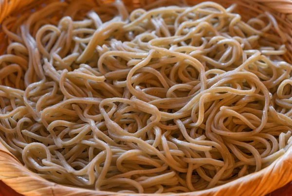 Close-up on a traditional Japanese basic chilled soba noodles made from buckwheat and served in the mori soba style in a bamboo weave flat basket called zaru soba.