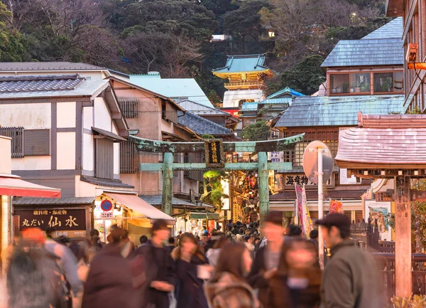 Kanagawa, Enoshima - 25 Aralık 2022 Enoshima Tapınağı 'nın Benten Nakamise Alışveriş Caddesi' nin üst ucundaki Zuishinmon Kapısı 'na giden bronz torii kapısına doğru ilerleyen turist kalabalığı.