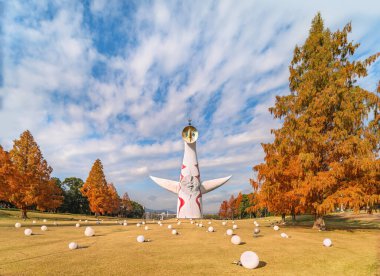 Japonya, Osaka - Aralık 04 2022: Japon Güneş Kulesi ya da Taiyou no tou Taro Okamoto tarafından 70 Fuarı için yaratıldı kuru çimlerin 70 metre üstünde ve kozalaklı ağaçlar sonbahar mevsiminde kahverengileşti..