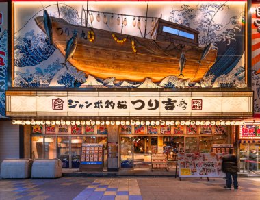 osaka, japan - dec 04 2022: Balıkçılık ve deniz ürünleri restoranı Jumbo Tsuribune Tsurikichi, deniz dalgalarında yüzen bir balıkçı teknesiyle Ukiyo-e ustası Katsushika Hokusai 'nin Büyük Dalgası' nı ön cephede uyandırıyor..