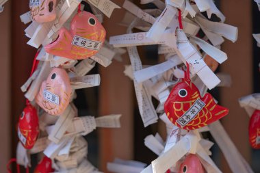 Şirin pembe ve kırmızı Japon Aitai mikuji falına yakından bak. Kawagoe şehrinin hikawa tapınağında aşk kaderini öngören, kartonpiyer şeklinde balık şeklinde kağıtlar hazırla.