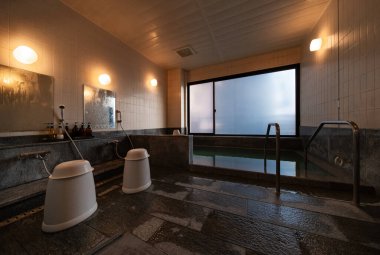 Kapalı alan Japonların gönderdiği sakin bir hamamda geleneksel banyo küvetleri, yumuşak ortam ışıkları ve sıcak sulardan yükselen buhar dinlenmek için huzurlu bir geri çekilme sunuyor..