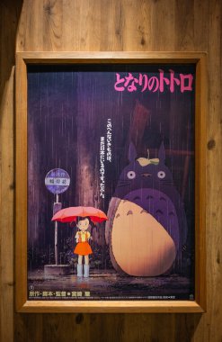 Tokyo, odaiba - 22 Mayıs 2025: Hayao Miyazaki 'nin yönettiği Komşum Totoro' nun Japon film posteri Satsuki 'yi yağmur gibi yağan otobüs durağında nostalji ve sihir çağrıştırıyor..
