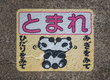 Shizuoka, atami - 26 Mart 2025: Japon trafik güvenliği durdurma levhası üzerinde panda resmi var ve çocukları caddeyi geçmeden önce sağa sola bakmaya teşvik ediyor..